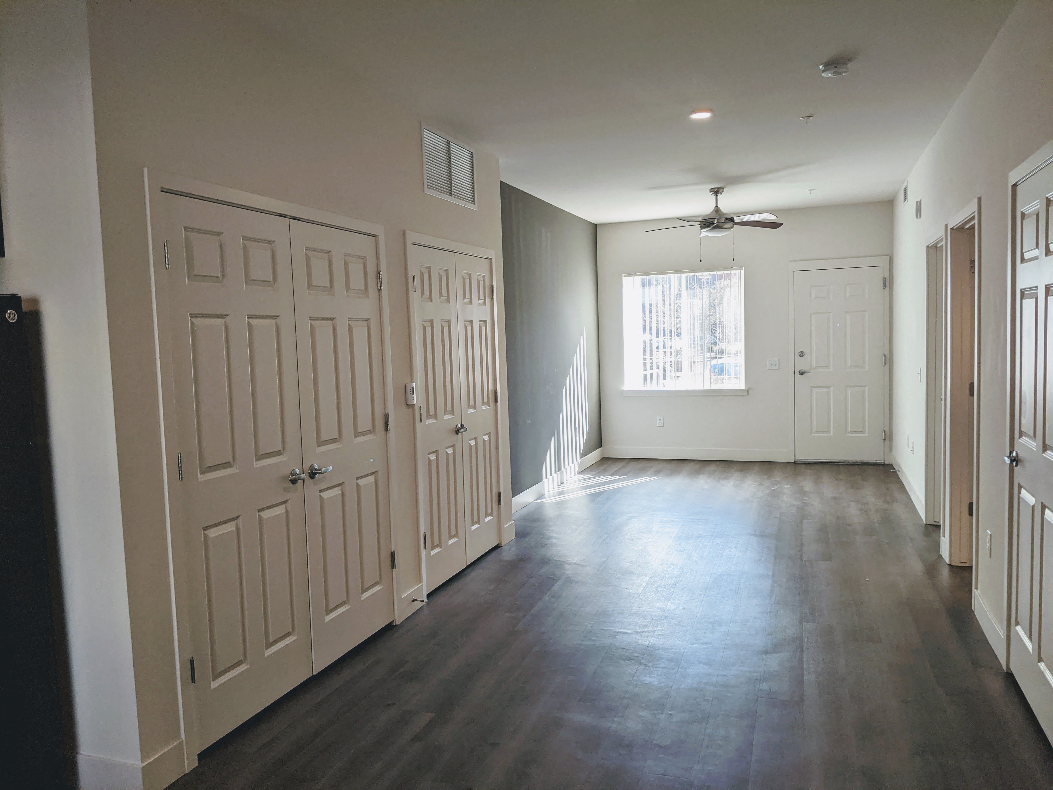 A view of the living space with a window and ceiling fan